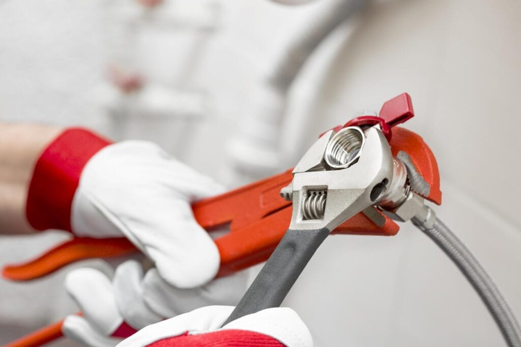 Plumber holding pipe wrenches for an emergency repair in Sarasota